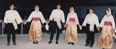 Χορευτές με λευκά πουκάμισα και χρυσές φούστες
